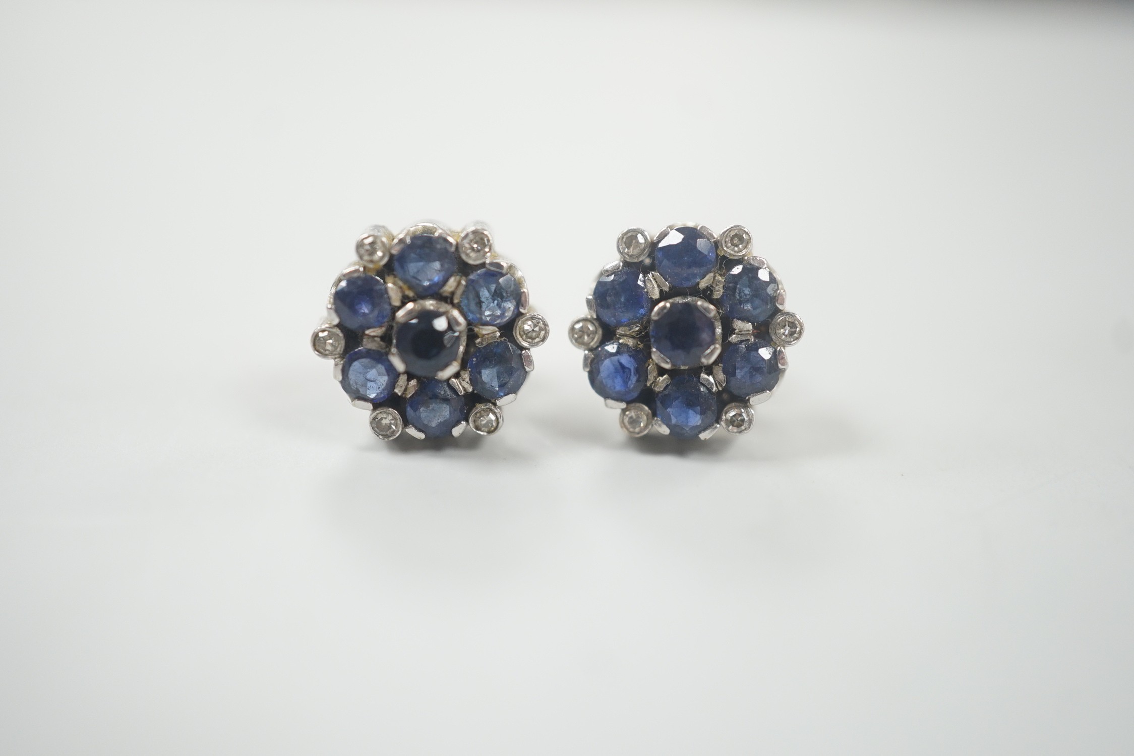 A pair of white metal, sapphire and diamond cluster set flower head ear studs, 10mm, gross weight 4.6 grams.